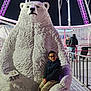 Lyam participe au concours pour gagner de l'argent avec cette photo : child, boy, glasses, polar_bear_statue, amusement_park, night, lights, ferris_wheel, people, statue, outdoor, smiling, jacket, pants, railings, metal_floor, winter, fun, family, entertainment