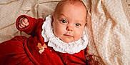Victoire participe au concours pour gagner de l'argent avec cette photo : baby, infant, child, red_clothing, white_collar, blanket, blue_eyes, cute, portrait, closeup, soft_texture, indoors, cozy, smiling, face, person, toddler, newborn, warm_colors, sleepwear