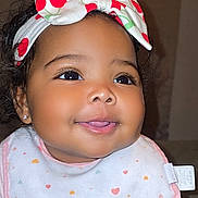 Emery joined the competition — help win amazing prizes! baby, infant, smiling, face, headband, bow, cherry_pattern, bib, clothing, crawling, hands, cute, happy, portrait, child, indoors, skin, person, closeup, young