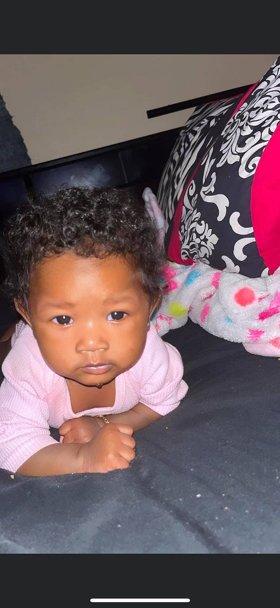 Amiri Dior is registered to the contest to win money with this photo: arm, baby, baby_toddler_clothing, cheek, child, eyelash, finger, flash_photography, fun, gesture, happy, magenta, person, pink, room, sitting, skin, smile, thumb, toddler