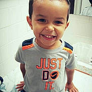 Mason is registered to the contest to win money with this photo: child, boy, smiling, tshirt, shorts, bathroom, mirror, marble_counter, hairstyle, mohawk, happy, indoor, casual_clothing, sitting, portrait, face, hands, young_child, cute, joyful