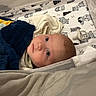 Connor is registered to the contest to win money with this photo: baby, blanket, crib, infant, face, bed, sleeping_area, cute, animal_print, pacifier, soft_texture, child, indoors, portrait, young, cozy, clothing, head, lying_down, resting
