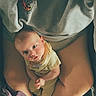 Connor is registered to the contest to win money with this photo: baby, child, person, legs, sweatshirt, purple_cloth, indoor, seated, looking_up, curious, cozy, human, casual_clothing, skin, head, face, hands, infant, comfort, relaxed