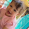 child, toddler, smiling, curly_hair, pink_shirt, closeup, happy, face, portrait, indoors, cute, person, joyful, baby, expression, childhood, bright, casual_clothing, young, playful
