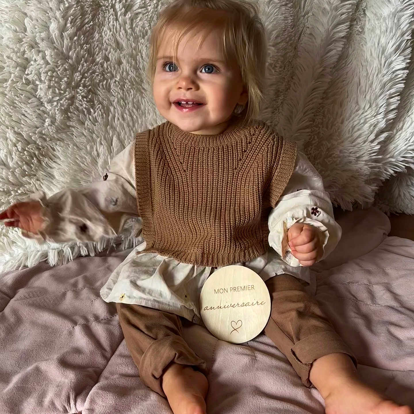 ève participe au concours pour gagner de l'argent avec cette photo : baby, blue_eyes, brown_clothing, celebration, child, cozy, cute, first_birthday, floor, hair_bow, happy, indoors, knit_vest, plush_blanket, portrait, sitting, smiling, soft_texture, toddler, wooden_plaque