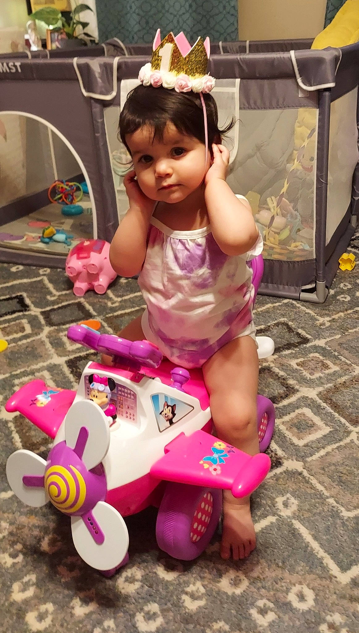 Zara is registered to the contest to win money with this photo: child, fashion_accessory, fun, headpiece, human_body, human_leg, magenta, person, photograph, pink, play, purple, riding_toy, sitting, snapshot, thigh, tiara, tire, toddler, toy