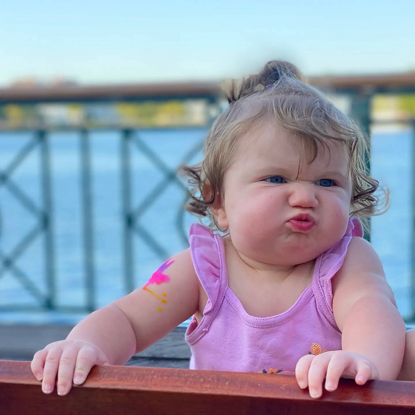 Gwendolyn is registered to the contest to win money with this photo: baby, baby_toddler_clothing, cheek, child, fun, grass, hair, hairstyle, hand, happy, iris, leisure, lip, nose, person, sitting, skin, sky, toddler, water