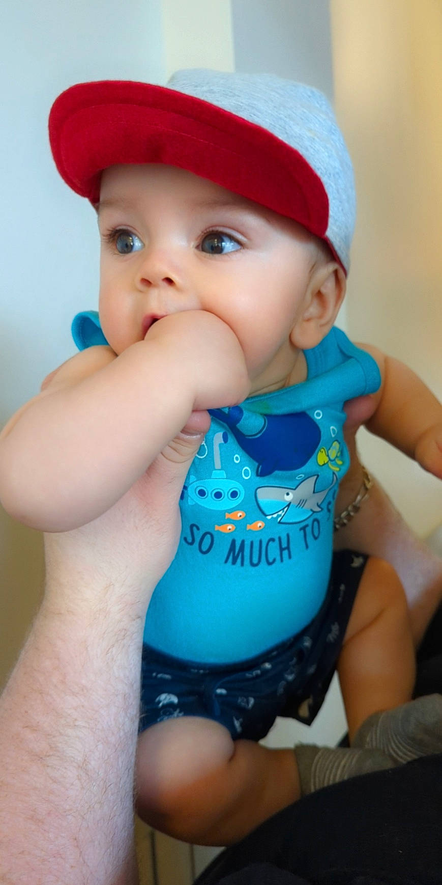 Rowan is registered to the contest to win money with this photo: aqua, azure, baby, baby_toddler_clothing, blue, cap, child, drinkware, finger, gesture, hand, happy, hat, headgear, headwear, lip, outerwear, person, skin, sleeve
