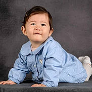 Mya participe au concours pour gagner de l'argent avec cette photo : baby, background, blue_jacket, child, clothing, crawling, curious, cute, expression, face, feet, hands, indoor, infant, portrait, smiling, soft_lighting, studio, white_socks, young_child