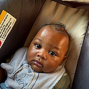 Lujuan Oshea is registered to the contest to win money with this photo: baby, infant, car_seat, bottle, bib, blanket, close_up, portrait, child, cute, face, expression, indoors, clothing, young_child, holding, resting, person, soft_lighting, newborn