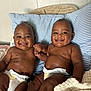 baby, infant, smiling, diaper, holding_hands, bed, pillow, blanket, cute, happy, twin, child, indoor, skin, face, person, sitting, young, friendship, joy