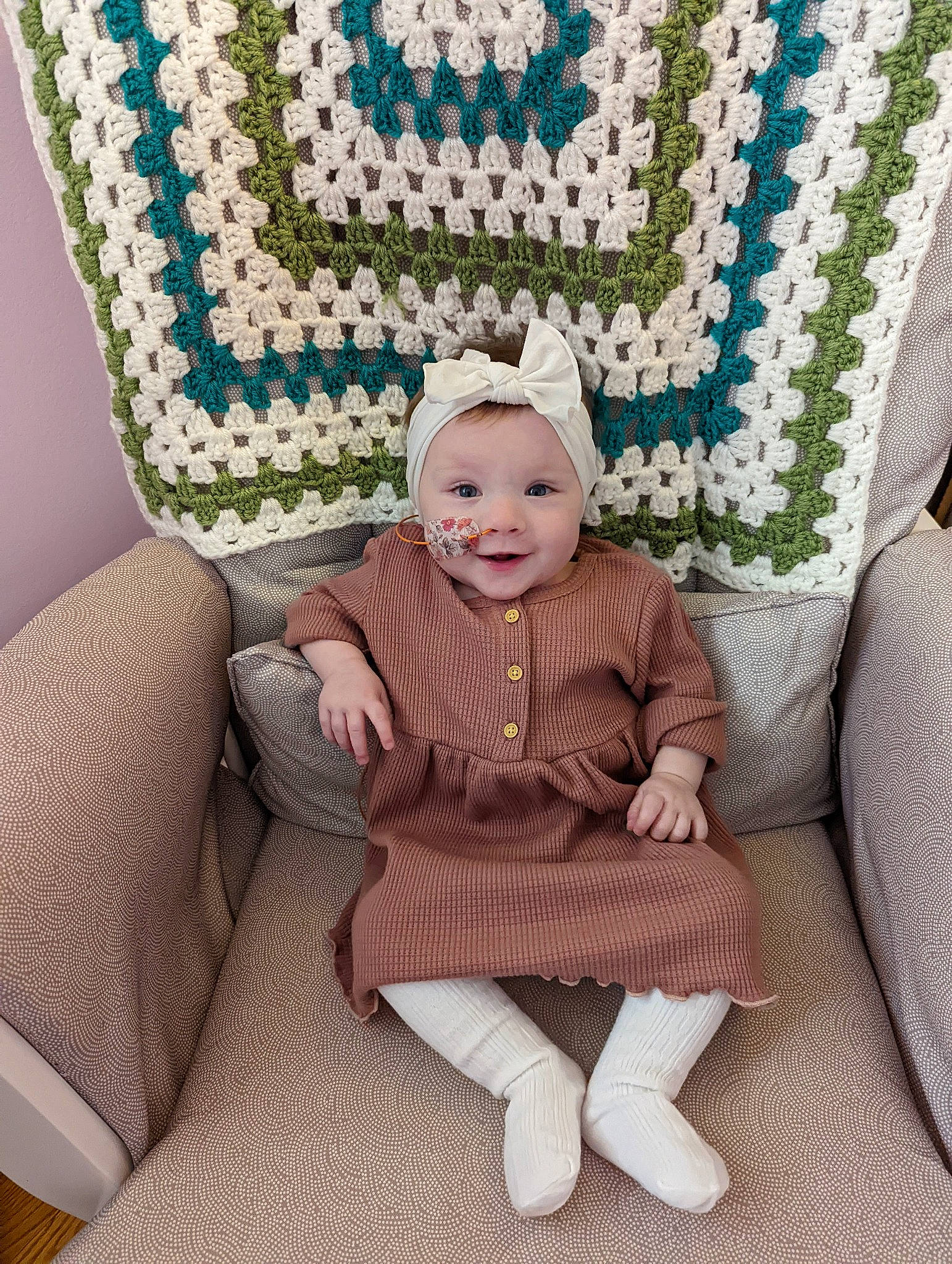 Fiona joined the competition — help win amazing prizes! baby, baby_toddler_clothing, cap, chair, comfort, eye, face, green, happy, hat, head, headgear, headwear, linens, outerwear, pattern, person, sleeve, smile, textile