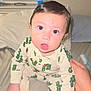 baby, child, pajamas, cactus_pattern, bed, hand, indoor, person, face, eyes, expression, sleepwear, curious, infant, cute, skin, hair, mouth, sitting, support