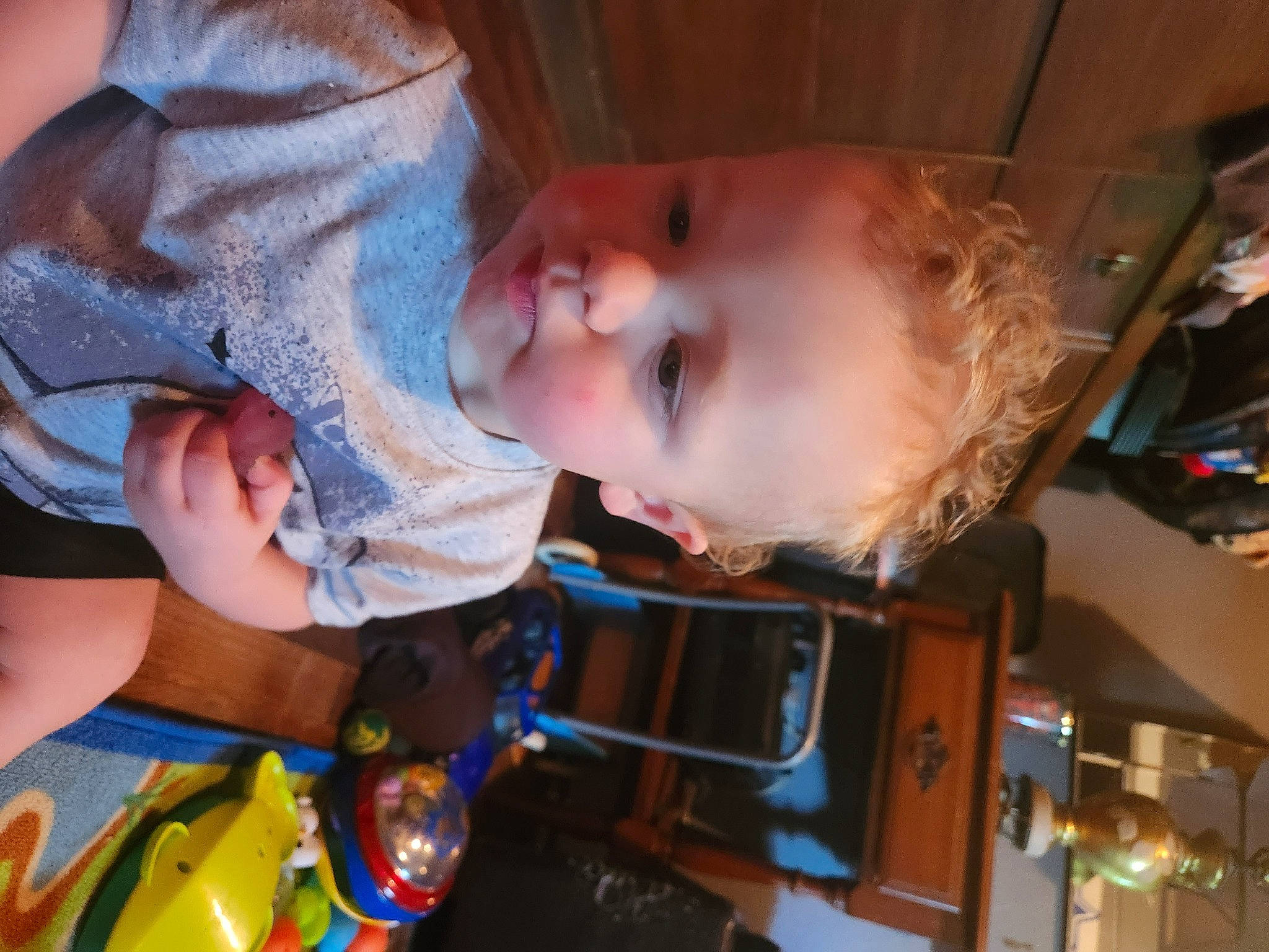 Issac is registered to the contest to win money with this photo: baby, baby_toddler_clothing, cheek, child, ear, facial_expression, finger, fun, hairstyle, happy, human_body, iris, mouth, nose, person, play, room, skin, t_shirt, toddler