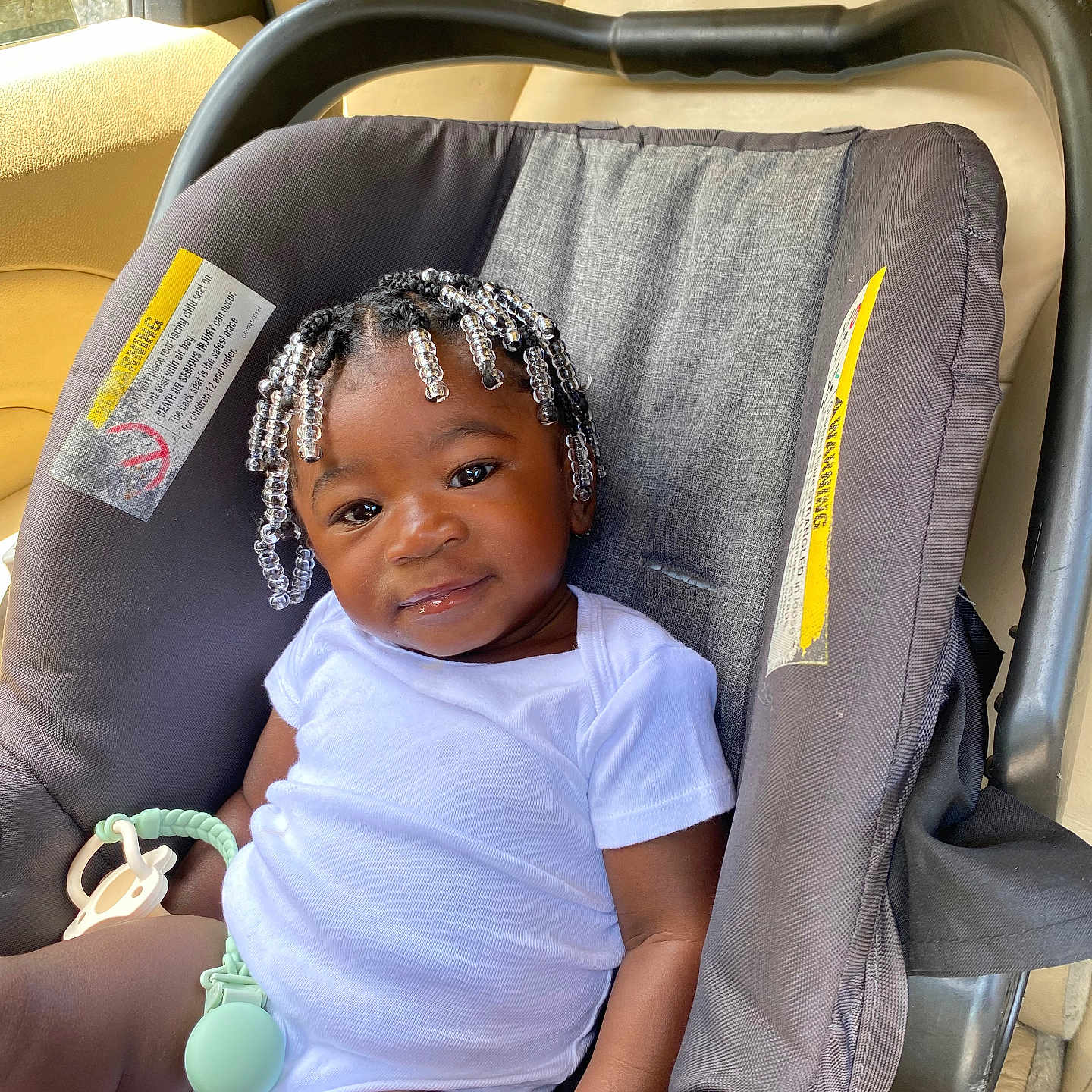 Chaunsea Harris is registered to the contest to win money with this photo: baby, beaded_hair, car_interior, car_seat, child, child_seat, cute, hair_beads, happy, indoor, infant, person, portrait, relaxed, seat, seatbelt, smile, sunlight, white_onesie, young_child