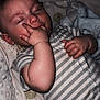 baby, sleeping, hand, blanket, striped_clothing, infant, bed, pajamas, peaceful, cozy, soft_texture, child, cute, resting, indoors, portrait, young_child, sleep, comfort, relaxation