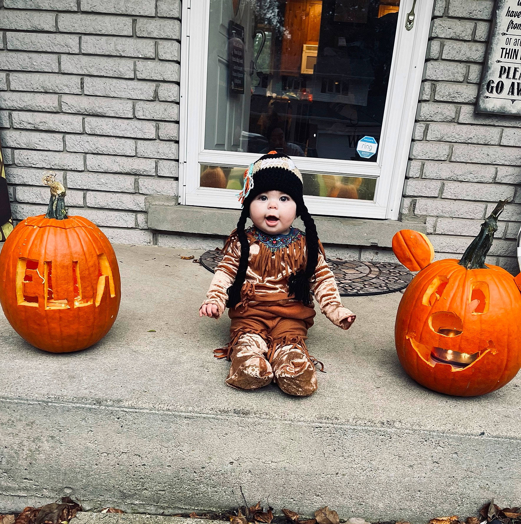 Ella is registered to the contest to win money with this photo: calabaza, child, cucurbita, door, flooring, gourd, grass, happy, headwear, jack_o_lantern, natural_foods, orange, person, plant, pumpkin, sitting, squash, toddler, vegetable, window