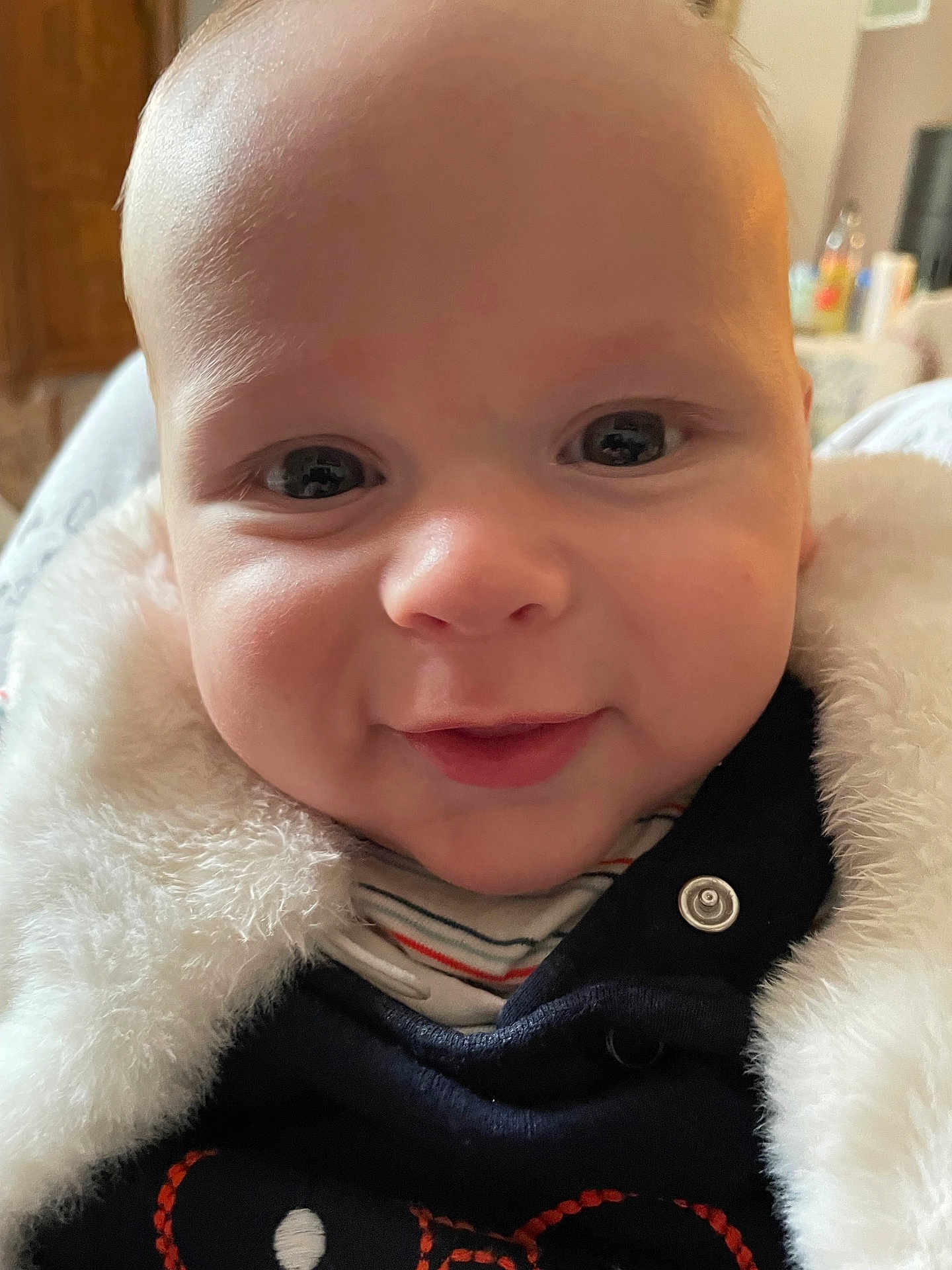 Gaël participe au concours pour gagner de l'argent avec cette photo : baby, infant, close_up, smile, cheeks, eyes, face, fuzzy_coat, jacket, button, skin, portrait, indoors, cuddly, hood, newborn, gaze, happy, cute, soft_texture
