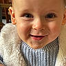 baby, child, closeup, cozy, cute, drool, eyes, face, happy, head, indoors, jacket, knitwear, mouth, person, portrait, skin, smile, sweater, young