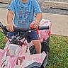Damien joined the competition — help win amazing prizes! child, toddler, boy, atv, quad_bike, pink, camouflage, outdoor, driveway, grass, road, sidewalk, vehicle, handlebars, wheels, helmetless, shorts, blue_shirt, portrait, daylight