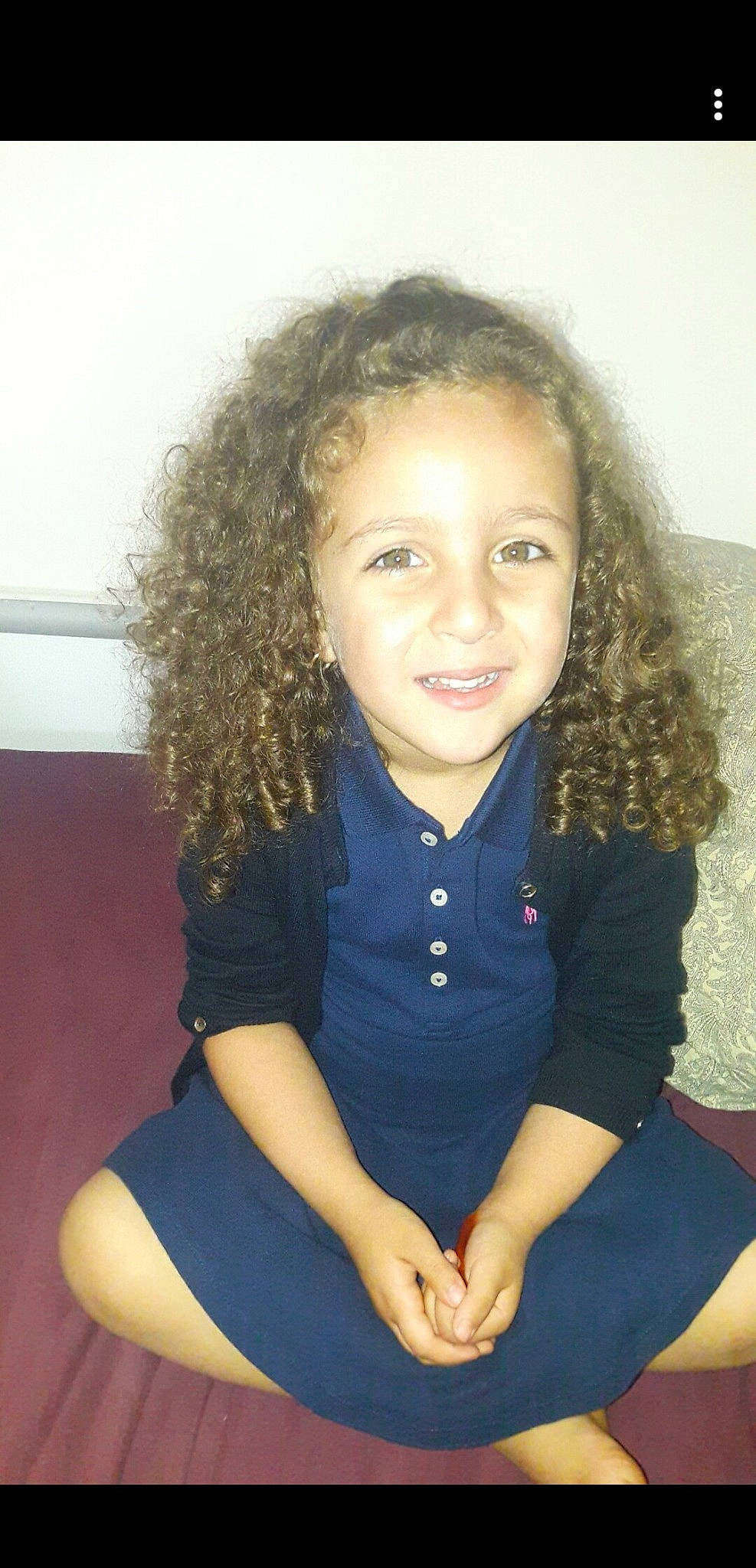 Naïla a rejoint le concours — aidez-le/la à gagner de superbes lots ! black_hair, child, child_model, chin, hair, hairstyle, joy, long_hair, person, sitting, smile