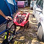 bicycle, bike_trailer, camping, car, dirt, dog, flag, grass, hat, laundry, mesh_window, outdoor, person_hand, pet, recreation, shadow, sunlight, tent, transport, wheel