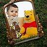 Josiah joined the competition — help win amazing prizes! baby, child, mirror, reflection, plush_toy, winnie_the_pooh, grass, outdoor, toy, blue_eyes, curious, chewing, card, yellow, red_shirt, cute, portrait, close_up, playful, person