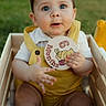Josiah joined the competition — help win amazing prizes! baby, child, infant, yellow_overalls, wooden_crate, outdoor, grass, milestone_card, 6_months, cute, portrait, face, hand, toy, curious, sitting, young_child, happy, closeup, person