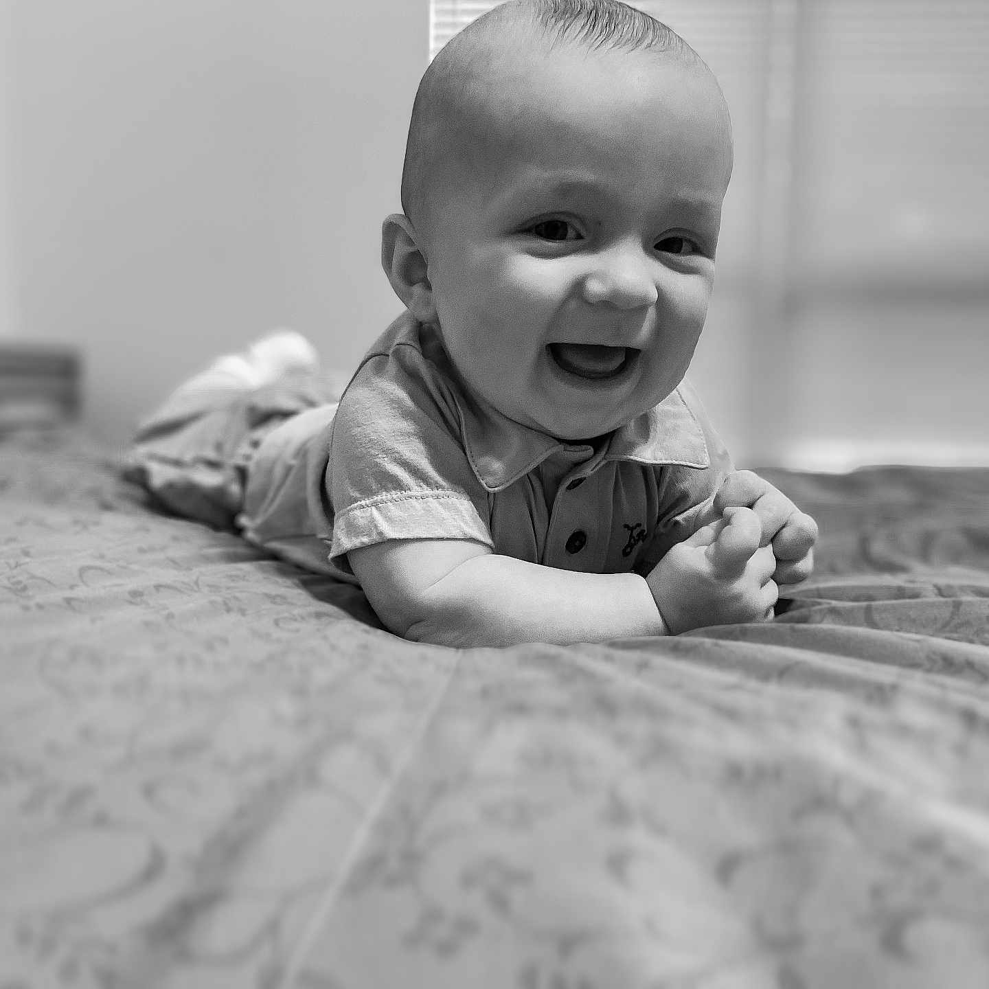Caeson is registered to the contest to win money with this photo: baby, bed, black_and_white, blanket, child, clothing, cute, expression, face, hand, happy, head, home, indoors, infant, lying_down, person, portrait, smiling, toddler