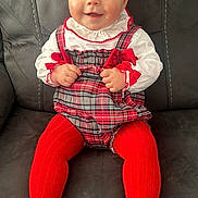 Dolly joined the competition — help win amazing prizes! baby, child, smiling, red_tights, plaid_dress, white_blouse, couch, indoor, sitting, happy, face, person, cute, portrait, hands, feet, infant, clothing, furniture, bright_eyes