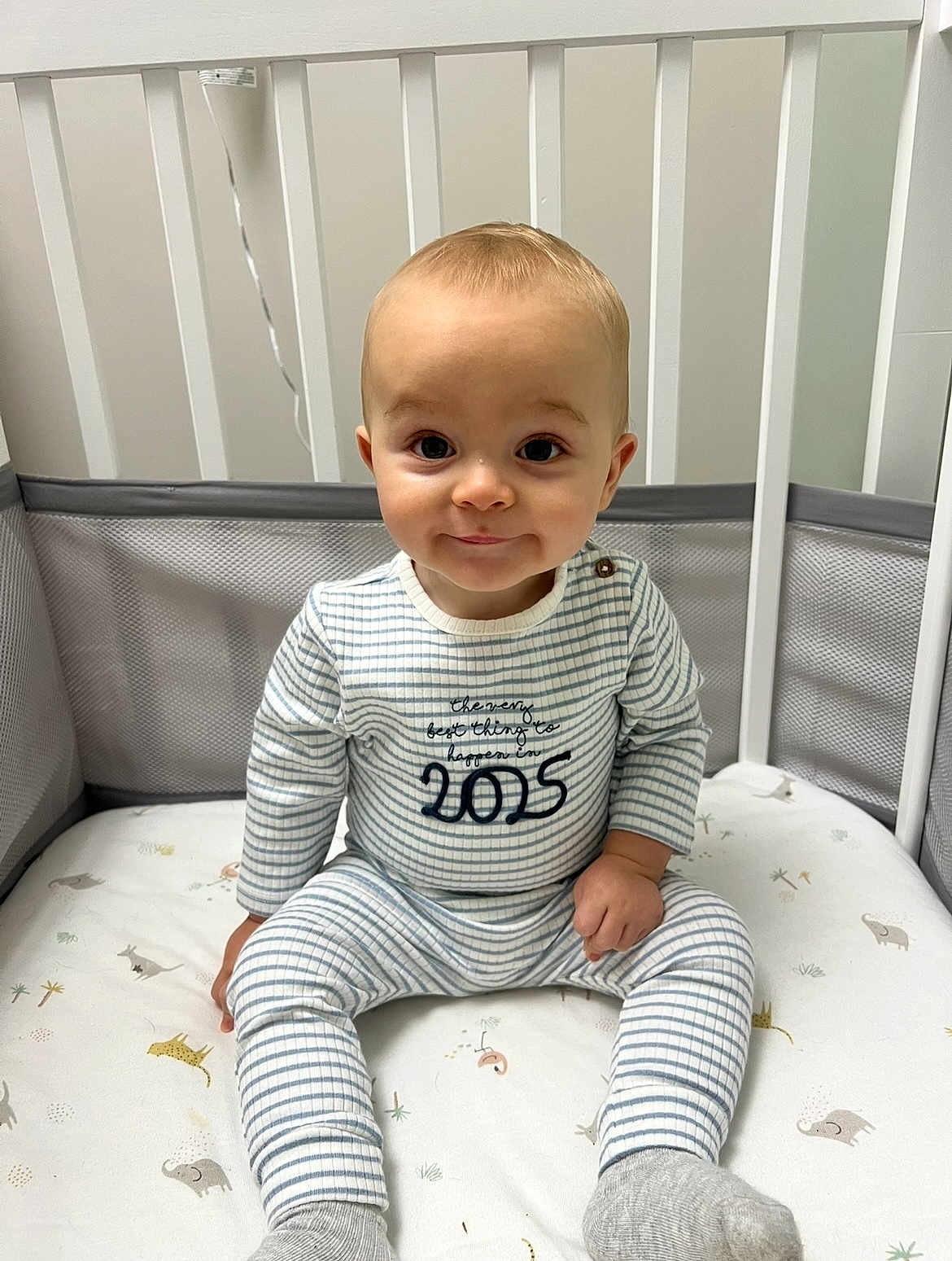 Hudson joined the competition — help win amazing prizes! baby, child, crib, pajamas, striped_clothing, smile, sitting, nursery, bedding, animal_print, sock, face, infant, cute, indoor, young_child, soft_lighting, happy, person, portrait