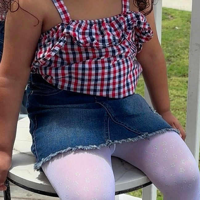 Queen is registered to the contest to win money with this photo: black_boots, casual, child, curly_hair, denim_skirt, fashion, girl, greenery, happy, outdoor, plaid_top, playful, portrait, smiling, stool, summer, sunglasses, sunny, white_tights, wooden_deck