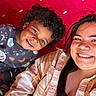 Carson is registered to the contest to win money with this photo: child, woman, smiling, selfie, curly_hair, red_background, plaid_shirt, casual_clothing, portrait, happy, indoor, face, people, toddler, childhood, joy, closeup, headshot, diverse, togetherness