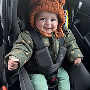 Lyan a rejoint le concours — aidez-le/la à gagner de superbes lots ! baby, car_seat, child, smile, hat, jacket, seatbelt, clothing, infant, car_interior, cute, portrait, sitting, happy, young_child, socks, green_pants, toddler, safety, warm_clothes