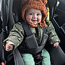 baby, car_seat, child, smile, hat, jacket, seatbelt, clothing, infant, car_interior, cute, portrait, sitting, happy, young_child, socks, green_pants, toddler, safety, warm_clothes
