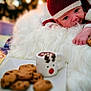 Hezekiah is registered to the contest to win money with this photo: baby, infant, cookie, hot_chocolate, mug, blanket, red_hat, white_blanket, chocolate_chip_cookies, holiday, festive, cozy, cute, smiling, playful, lying_down, food, drink, warm, indoor