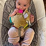 Isabella joined the competition — help win amazing prizes! baby, child, infant, smiling, plush_toy, seat, cushion, clothing, pants, socks, happy, cute, indoors, person, face, hands, toy, comfort, young, playful