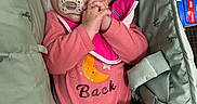 Isabella is registered to the contest to win money with this photo: baby, sleeping, pacifier, pink_clothing, blanket, stroller, cushion, shopping_cart, child, infant, cute, hands_clasped, face, head, cozy, soft_texture, indoor, rest, peaceful, portrait