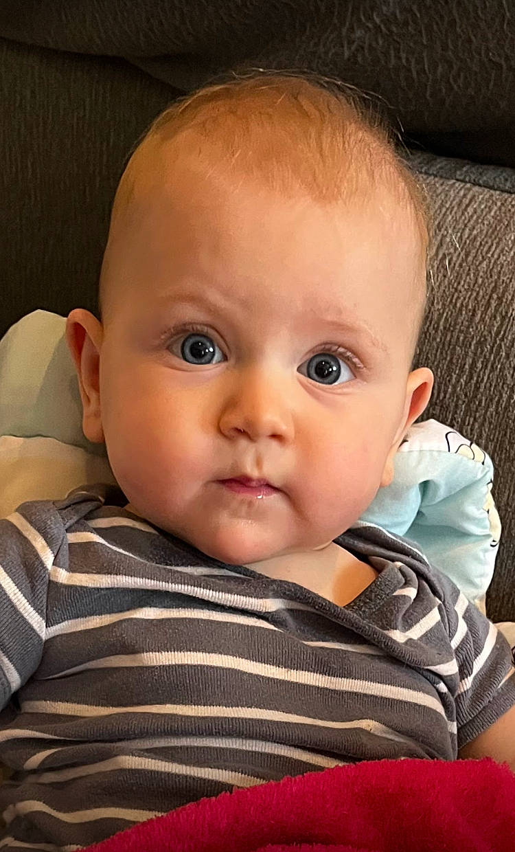 Jonathan is registered to the contest to win money with this photo: baby, baby_toddler_clothing, cheek, child, comfort, ear, eyebrow, eyelash, happy, iris, linens, lip, mouth, no_expression, nose, person, sitting, skin, sleeve, surprise