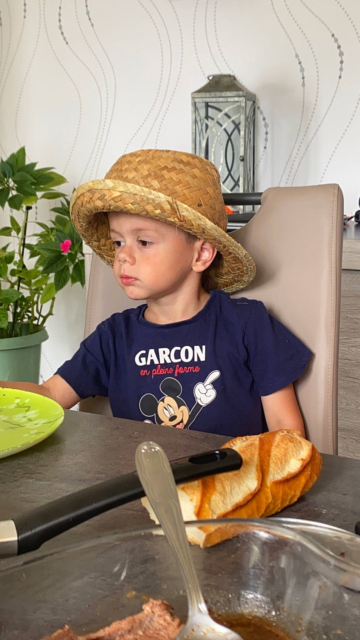 Noah participe au concours pour gagner de l'argent avec cette photo : cap, child, costume_hat, cowboy_hat, eyewear, fashion_accessory, fedora, flowerpot, gluten, hat, headgear, headwear, houseplant, person, plant, plate, sitting, sun_hat, t_shirt, table