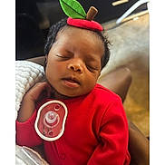 Mckynlee joined the competition — help win amazing prizes! newborn, baby, sleeping, portrait, closeup, face, red_outfit, apple_hat, leaf, pacifier, infant, indoors, cuddled, adult_hand, blanket, soft_lighting, peaceful, adorable, nursery, photography