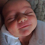 Lili Rose a rejoint le concours — aidez-le/la à gagner de superbes lots ! baby, infant, sleeping, smile, face, blanket, clothing, newborn, cozy, soft, cute, peaceful, portrait, closeup, child, person, indoors, relaxing, warm, comfort