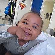 Yohan joined the competition — help win amazing prizes! baby, bed, blanket, closet, closeup, clothes, doorway, face, hand, indoor, infant, onesie, pillow, playful, portrait, poster, sheet, smile, superman_logo, tummy_time