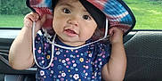 Evelynn is registered to the contest to win money with this photo: bucket_hat, building, car_interior, casual, child, clothing, curious_expression, daylight, floral_shirt, greenery, hat, holding, person, playing, portrait, sitting, supporting_arm, toddler, trees, window