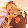 Gizmo is registered to the contest to win money with this photo: person, dog, hug, fluffy_dog, warm_light, indoor, close_up, affection, pet, casual_clothing, soft_focus, blurry_background, cute, companionship, portrait, warm_colors, home, cuddle, animal, love