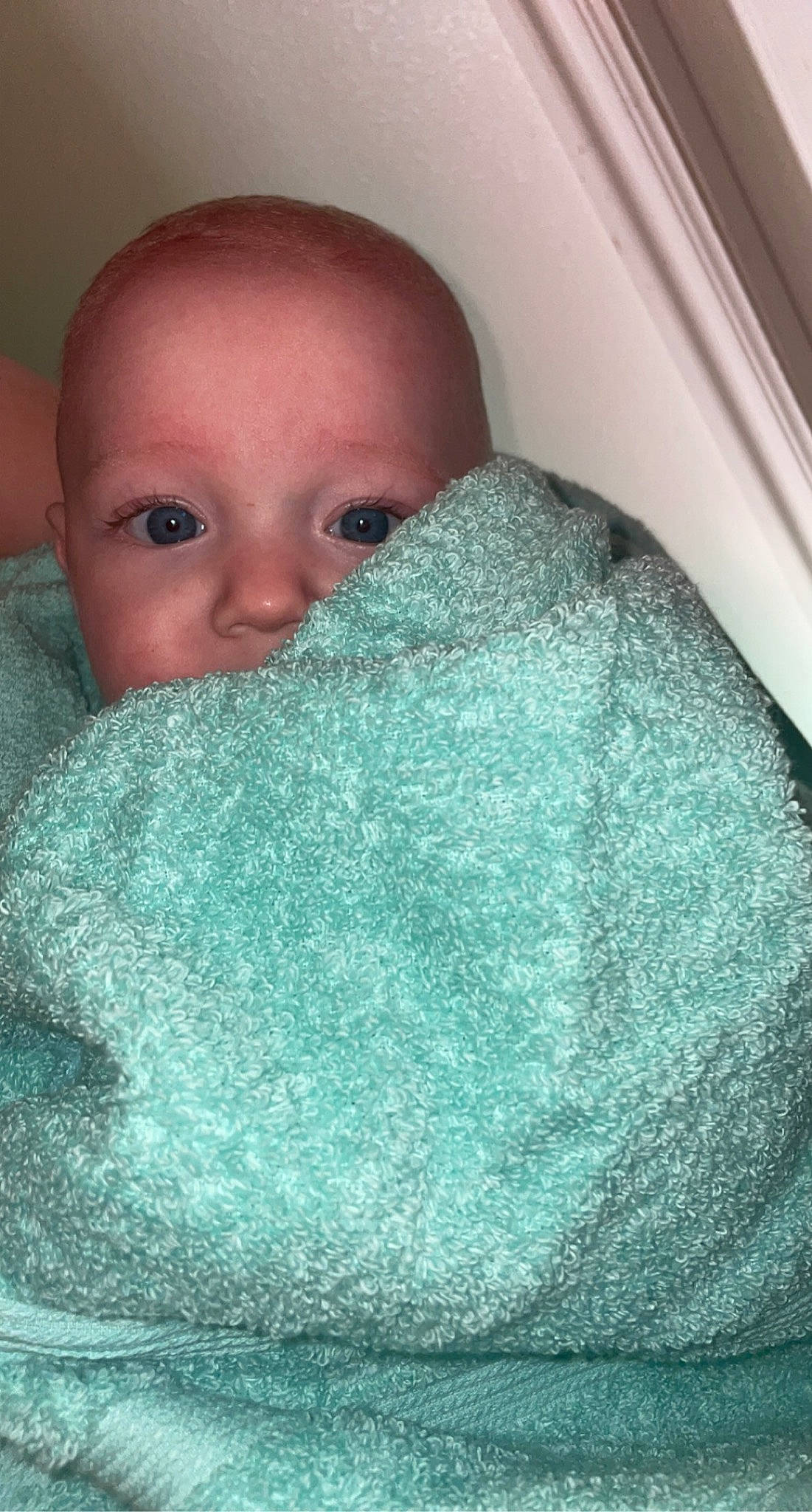 Rowan is registered to the contest to win money with this photo: baby, blanket, cheek, child, chin, comfort, eyebrow, face, linens, nose, person, skin, teal, toddler, towel, turquoise