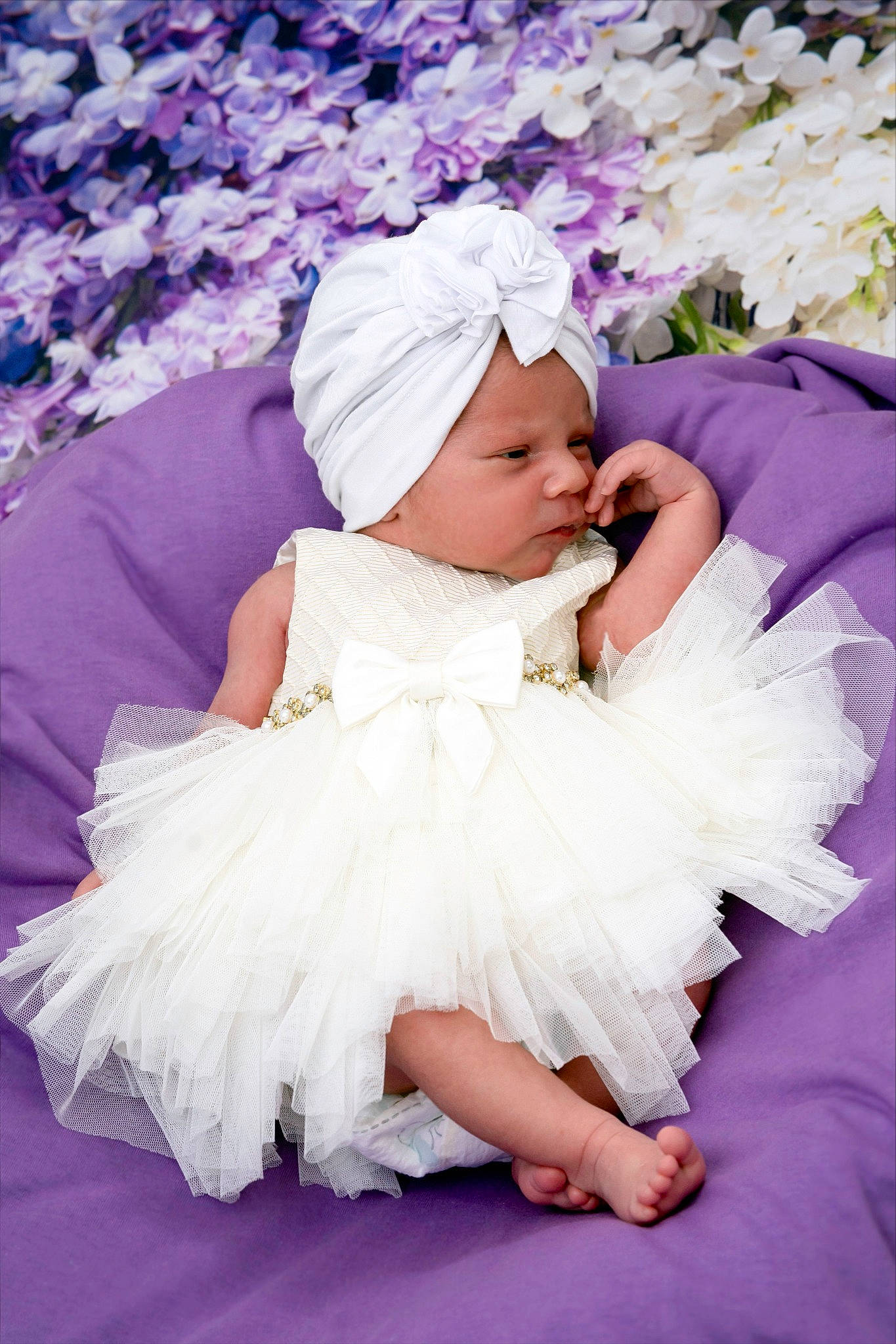 Emily is registered to the contest to win money with this photo: baby, baby_toddler_clothing, child, dress, embellishment, event, fashion_accessory, flash_photography, hair_accessory, happy, headpiece, headwear, magenta, peach, person, petal, pink, purple, skin, textile