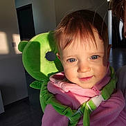 Lavinia participe au concours pour gagner de l'argent avec cette photo : toddler, child, baby, blue_eyes, pink_fleece, plush_backpack, green_backpack, indoor, smile, face, hair, hand, sunlight, shadow, modern_home, door, person, cute, portrait, warm_lighting