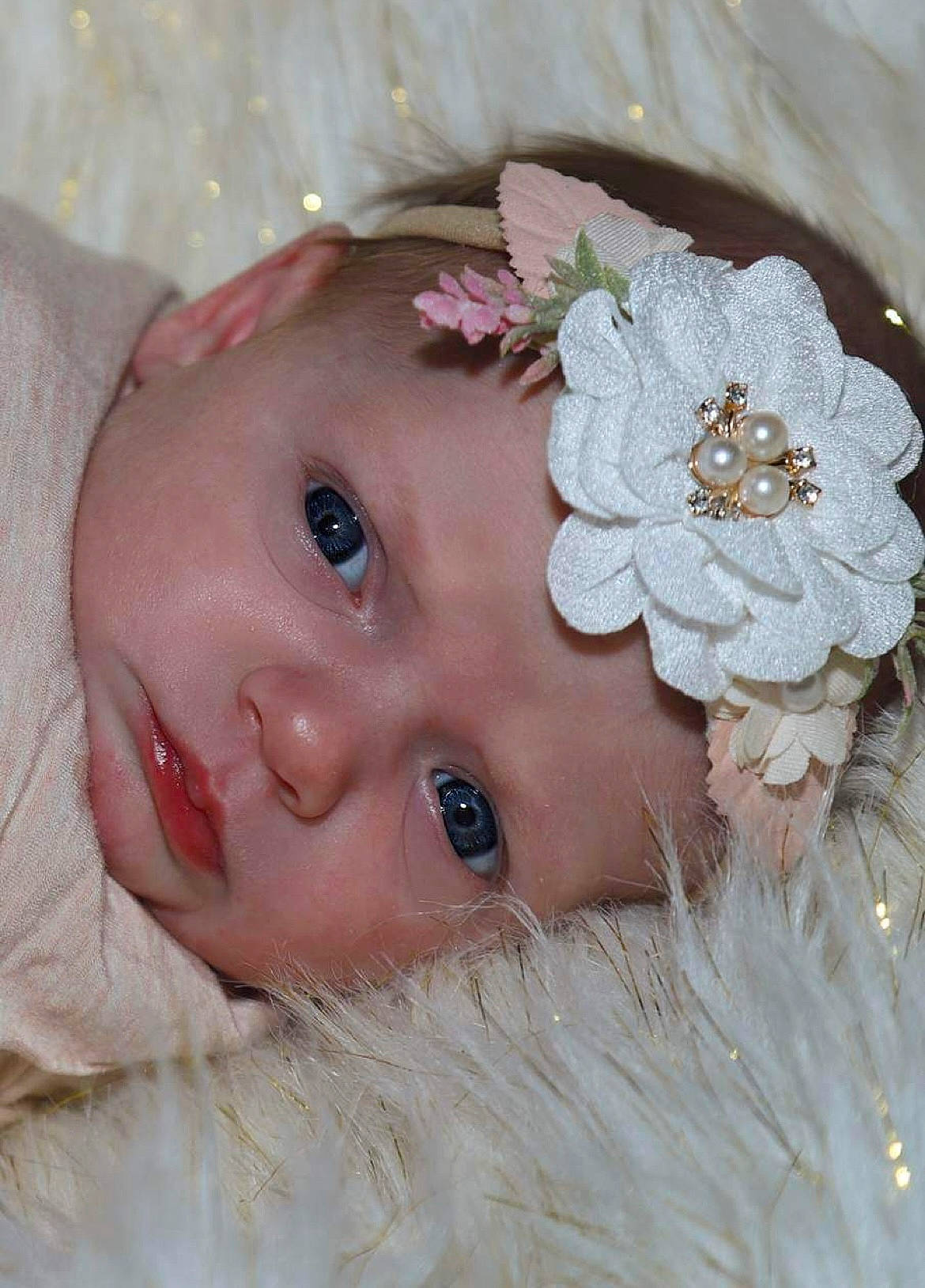 Macie is registered to the contest to win money with this photo: baby, bridal_accessory, embellishment, eye, eyebrow, eyelash, flower, hand, headband, headgear, headpiece, headwear, iris, lip, person, petal, pink, plant, product, skin