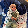 Luca joined the competition — help win amazing prizes! baby, infant, blanket, towel, footprint_pattern, clothing, sherpa_jacket, pants, socks, indoor, flooring, expression, surprised, cute, child, person, laying, texture, cozy, warm